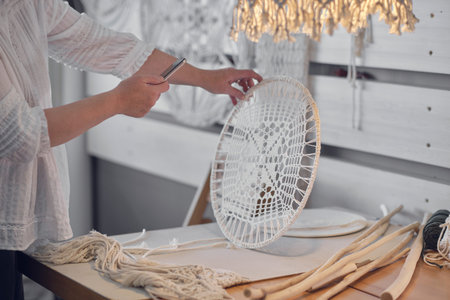 craftswoman photographs her product for sale on the Internet. hobby as a source of income. elderly...