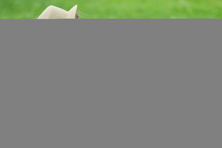 woman with pen writing on notebook on grass outside.の写真素材