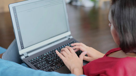 middle-aged woman shopping online. Woman use laptop in home. weekend in wooden armchair couch....