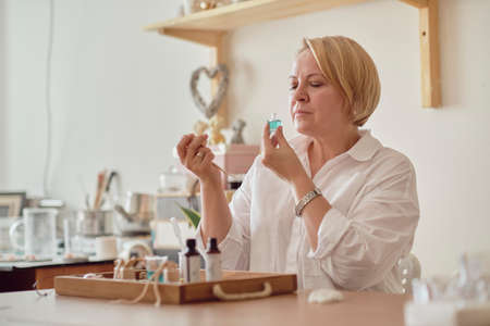 Close-up of a pipette with oil and a glass bottle. woman pouring perfume in bottle. Perfume creating workshopの写真素材