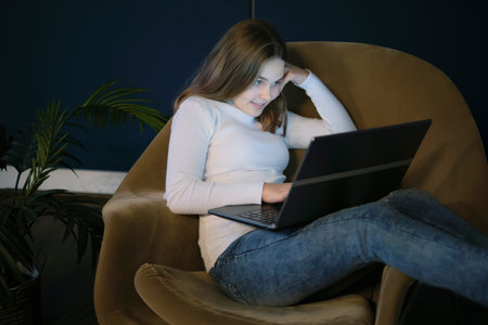 teen girl watching video on laptop at night