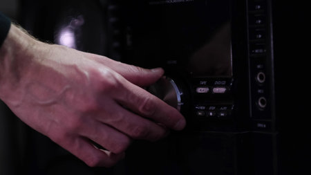 Mans hand adjiusting volume knob of subwoofer audio amplifier,volume control music concept. Raise the sound on musical equipment.の写真素材