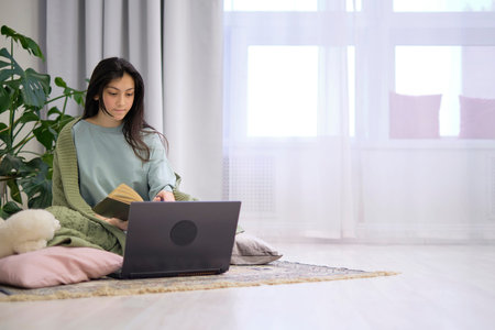 Teenage girl doing homework in the bedroom on the floor. teen girl school student write notes watch...