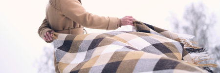defocus portrait of a woman in a snowy forest, wrapped in a blanket. woman enjoying winter moments...