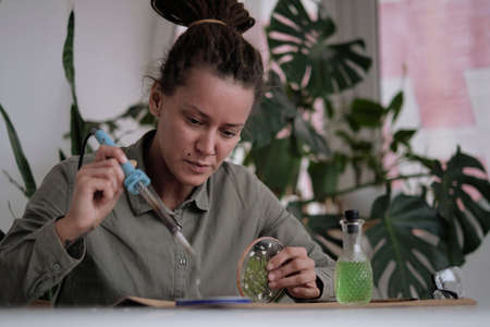 woman fixes glass plates. A picture of dried flowers. Master class on creating frame. be more creatively engaged. A Life of Happiness and Fulfillmentの写真素材