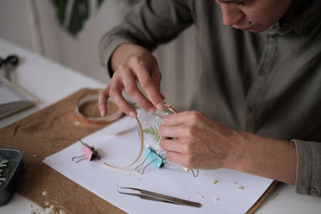 woman fixes glass plates. A picture of dried flowers. Master class on creating frame. be more creatively engaged. A Life of Happiness and Fulfillmentの写真素材