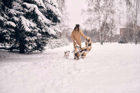 woman in a snowy forest, wrapped in a blanket. woman enjoying winter moments in a snowy park. frozen winter day. simple Life key to happinessの写真素材