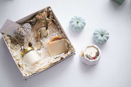 Preparing care package, seasonal gift box with soap and candle. Personalized eco friendly basket for family and friends for thanksgiving, christmas, mothers and fathers day holidays.の写真素材