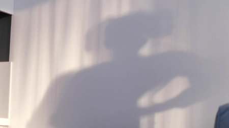 defocus little boy playing with shadows on the wall. shadow of a dancing boy reflected on the wall,...