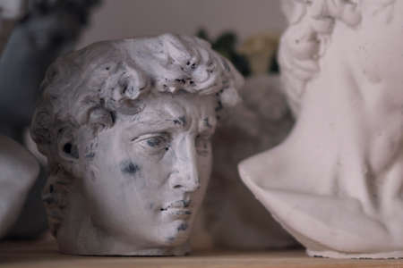 group of busts of David stand on a shelf. sculptors workspace. antique plaster bustsの写真素材
