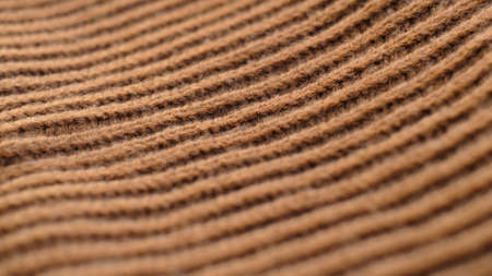 Textile abstract background. Clothing industry concept. Wavy clean material. Fibers of knitted clothes brown white threads. Knitted fabric threads macroの写真素材