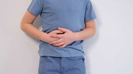 little boy experiences abdominal pain. Babys medication and health concept. Stomach ache. Suffering a young child. Food poisoning, abdominal pain. Health problems in children.の写真素材