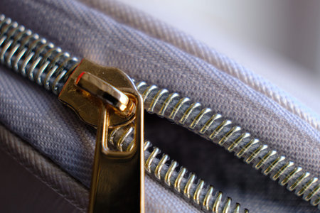 Selective focus, yellow metal zipper of a makeup bag or small purse macro pattern background