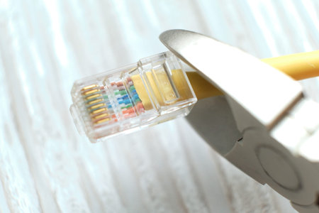 wire cutters cutting internet cable. Connection plugs and wires on old wooden background. Concept of...