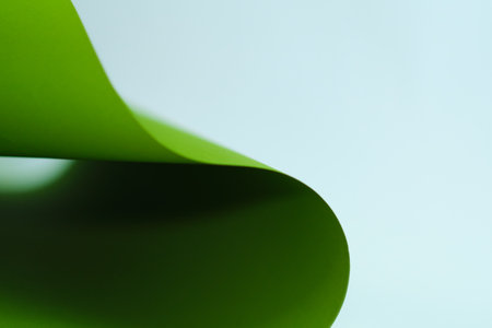 blurred green background with copy space. Top view. Close-up image. Concepts: lines and geometry. Creative geometric curved paper with light and shadows.の写真素材