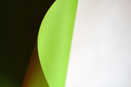green wave from paper on white background with copy space. Concepts: lines and geometry. defocus...