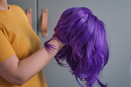 woman holds a bright purple wig in her hands. Womens beauty conceptの写真素材