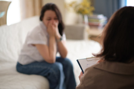 woman finds solace in the confidence and support of her therapist during a counseling session. The psychologist takes notes to ensure that the therapy remains confidentialの写真素材