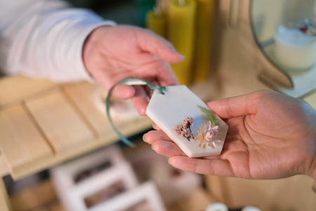 Handmade Aromatic Sachet Sale: A woman at a market hands over artisanal sachet to a customer, showcasing craftsmanship and natural scents.の写真素材