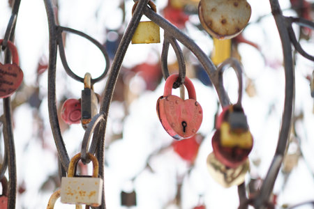 close up old rusty locks heart shaped on wire rope. Love lock on the bridge. tradition of hanging a barn lock on the wedding dayの写真素材