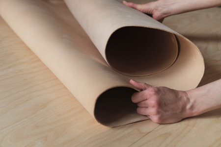 accomplished woman leather crafter featuring a roll of superior leather in her atelier, underlining...