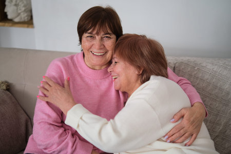two elderly sisters wrapped in a warm embrace, symbolizing the sharing of life experiences and...
