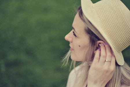 profile view of a woman in a hat, showcasing her unique facial feature a birthmark on her cheek. history and significance of birthmarks in various cultures.の写真素材