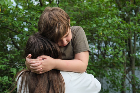 An authentic image of a mother and her pre-teen son in a garden, reflecting the values of childhood and family bonding for social initiativesの写真素材