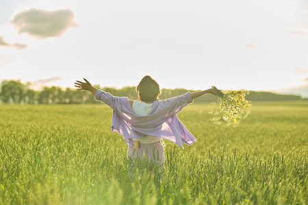 Elderly woman in stylish clothing relaxing in a lush meadow, embodying the fulfilling experiences offered in senior communitiesの写真素材