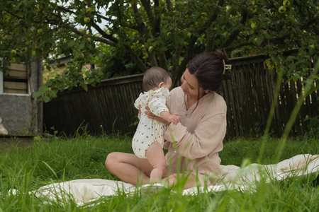 unique bond between mother and daughter, enveloped in tranquility of verdant park. Experiencing wonder of her childs first year, new mom finds peace and happiness in nature-filled escapeの写真素材