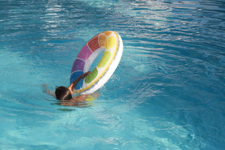 Vivid Tranquility: As the sun blazes overhead, a boy escapes into the pools calm, living his best...