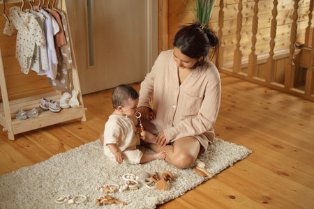 Through the Window of Love: A beaming mom and her little one enjoy the simple pleasures of a heartfelt hug, set against the backdrop of their sunlit, rustic abodeの写真素材