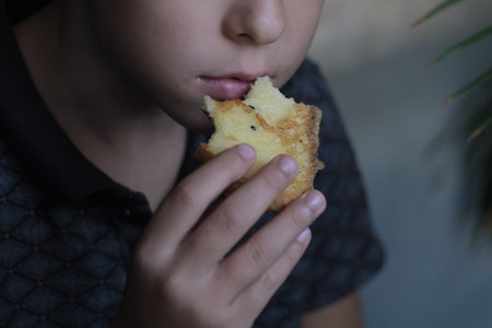 child savors a bite of sesame toast, a moment of simple pleasure. Such images highlight the shift towards mindful eating habitsの写真素材
