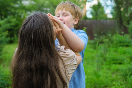 Under a cloudy summer sky, amid fresh laundry, a joyful play ensues between a mother and her redhead son. The setting and their happiness bring focus to the importance of eco-conscious living.の写真素材