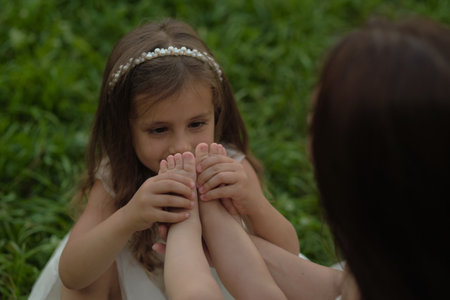 Delicate touch between siblings, a scene of kinship and gentle discovery. Evokes the nurturing role children often adopt with younger siblingsの写真素材