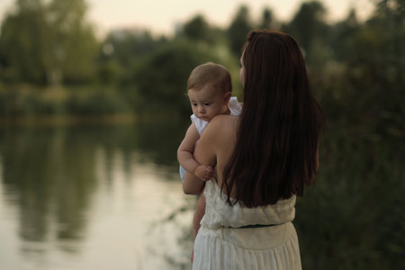 A girls elated expression as she hugs her mom near the woods. Against screen addiction, nature offers genuine moments.の写真素材