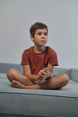With a mischievous smile, he sits relaxed, highlighting the importance of downtime in childrens increasingly busy lives.の写真素材