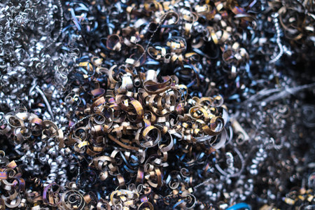 A mosaic of discarded steel curls reflects a spectrum of oily rainbows, hinting at the oily residues of industrial processes.の写真素材