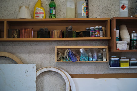 A woodworkers shelving is neatly stocked with polished wood pieces, colorful epoxy resins, and cleaning supplies, ready for crafting and finishing.の写真素材