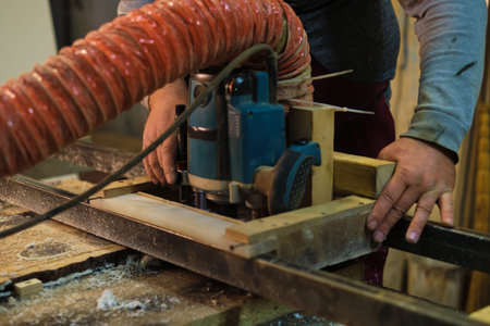 A woodworker feeds lumber. It underscores the harmony of man and machine in creation.
