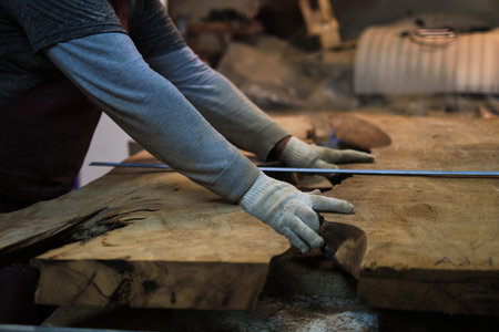Craftsman marks wood with a ruler and pencil. Precision in handcraft aligns with the bespoke...