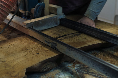 The woodworker carefully cuts through the timber, shaping a future piece of art. Every cut is a step towards the final masterpiece.の写真素材
