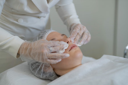 Pre-treatment skin preparation by a professional. Emphasizes the importance of groundwork in cosmetic care.の写真素材
