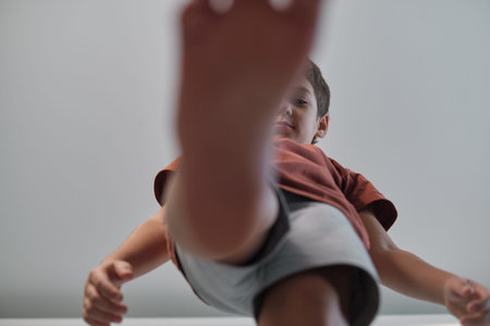 A child steps forward with one foot close to the camera, captured from a unique low-angle perspective. This photo reflects playful exploration and an energetic spirit.の写真素材