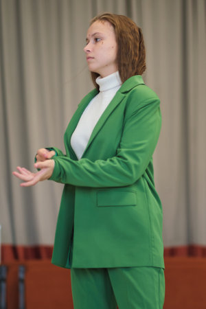 A poised individual standing in a professional setting, demonstrating readiness and confidence through her composed demeanor.の写真素材