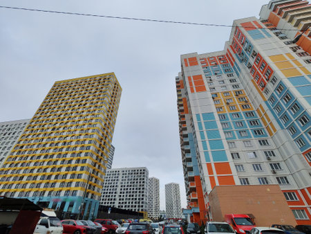 A towering residential building with pastel accents, featuring a wide array of windows and balconies. The design reflects the contemporary urban approach to high-density living in city environments.の写真素材