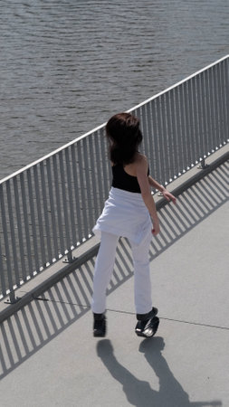 A woman in motion exercises near the water, embracing a dynamic fitness routine. The increasing popularity of rebound workouts showcases the shift towards fun and innovative exercise.の写真素材