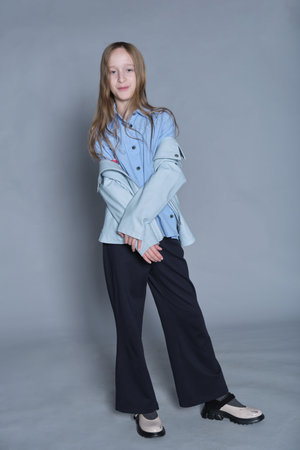 Playful and stylish girl in a blue shirt and jacket. Exemplifies the joy and fashion sense of today's youth.の写真素材