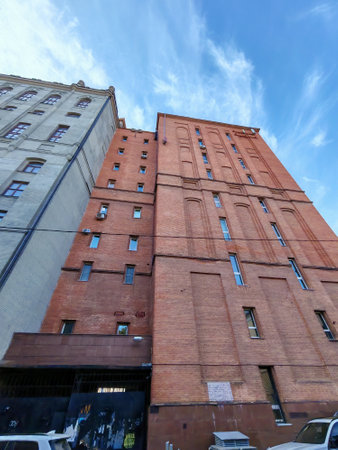 A historic red brick building with intricate patterns and a decorative balcony. The image highlights the durability of brick architecture and its aesthetic appeal, often seen in industrial or vintage urban design.の写真素材