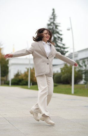 Captured in mid-twirl, a confident woman shows her coat lining while walking. The shot highlights dignity, movement, and the positive shift in perceptions of older adulthood.の写真素材